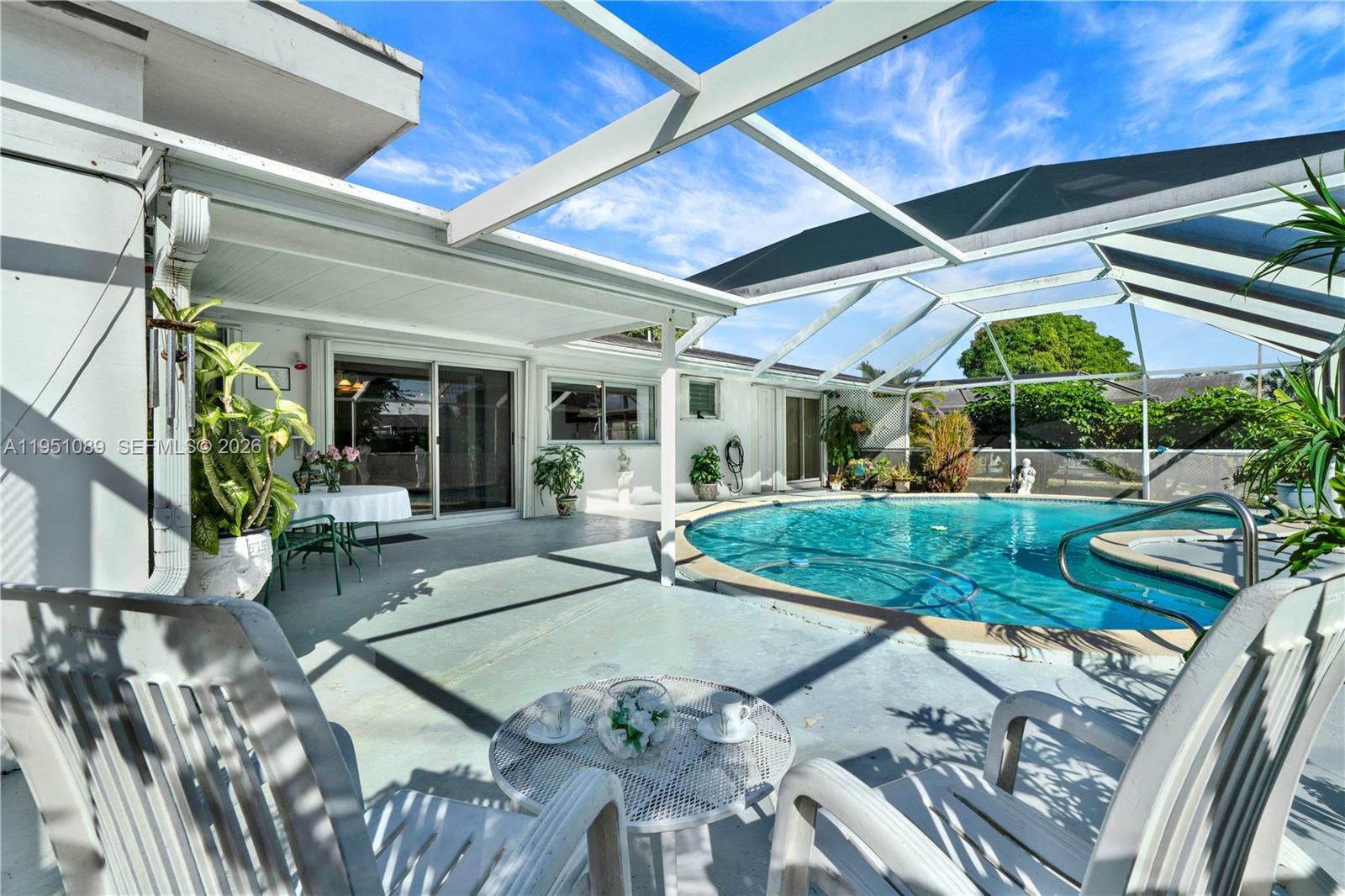 11260 Southwest 181st Terrace Miami, FL 33157 - Photo 31 of 57 a view of a patio with table and chairs potted plants with wooden floor