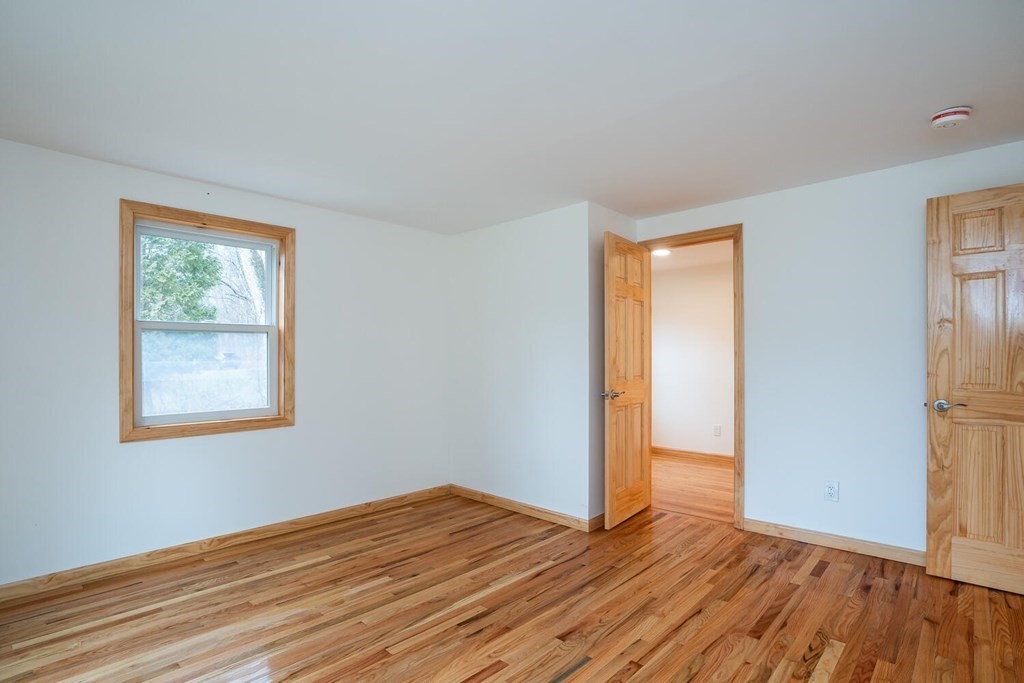 70 Leverett Road Amherst, MA 01002 - Photo 28 of 42 a view of an empty room with wooden floor and a window