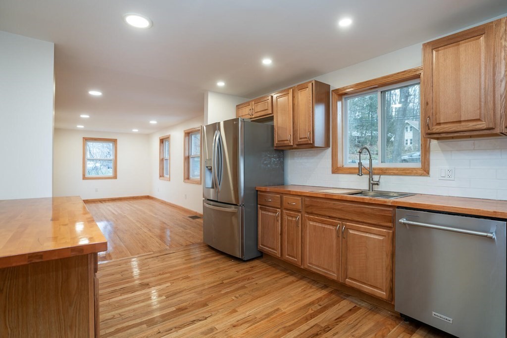 70 Leverett Road Amherst, MA 01002 - Photo 8 of 42 a kitchen with stainless steel appliances granite countertop a refrigerator a sink dishwasher a stove and white countertops with wooden floor