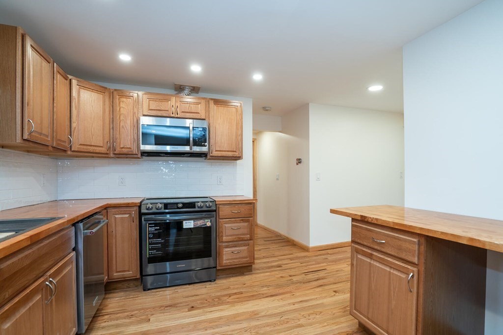 70 Leverett Road Amherst, MA 01002 - Photo 9 of 42 a kitchen with stainless steel appliances granite countertop a stove a refrigerator and a microwave