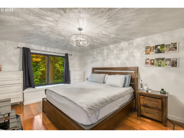 a bedroom with a bed and a dresser next to a window