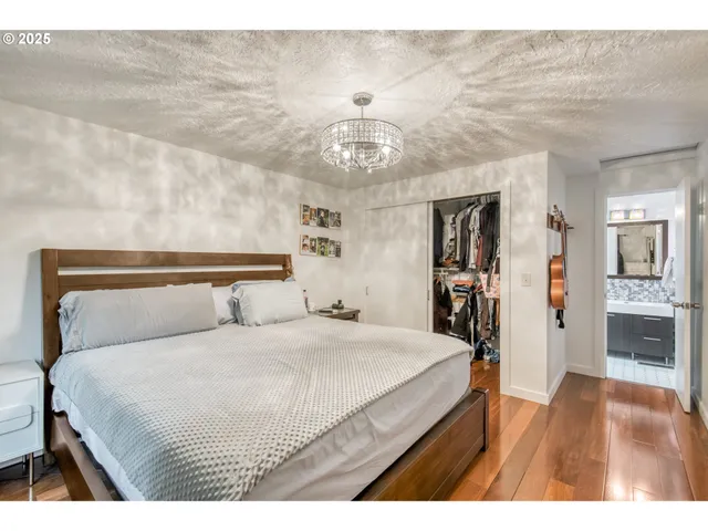 a bedroom with a large bed and a chandelier