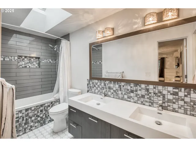 a bathroom with a sink a toilet and a mirror