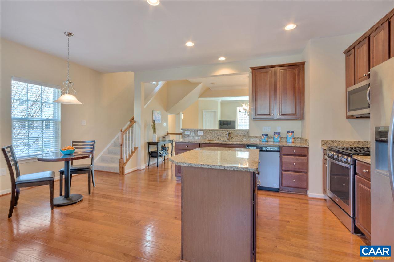 735 Rainier Road Charlottesville, VA 22903 - Photo 17 of 30 a kitchen with stainless steel appliances granite countertop a stove top oven a sink dishwasher a dining table and chairs with wooden floor