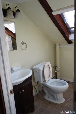 a bathroom with a toilet sink and mirror