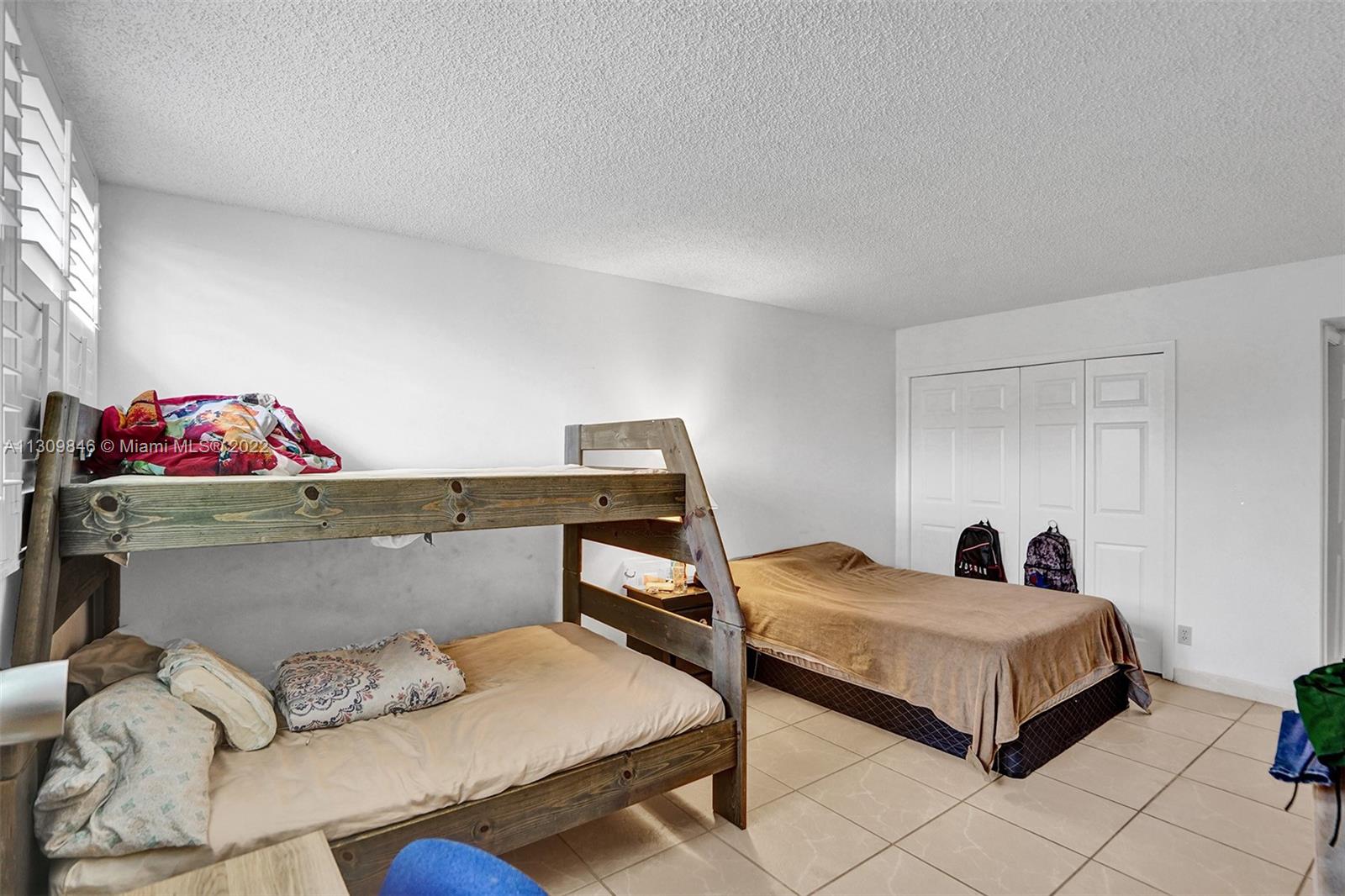 491 Racquet Club Road, Unit 101 Weston, FL 33326 - Photo 11 of 32 a bedroom with furniture and a couch