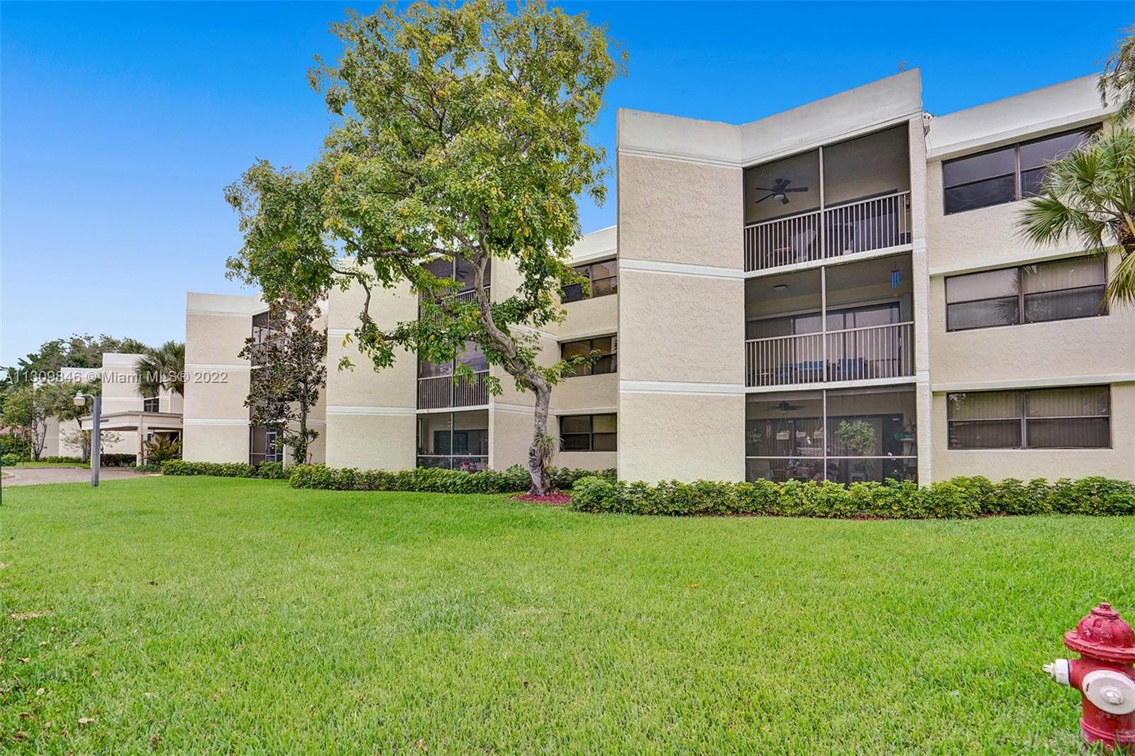 491 Racquet Club Road, Unit 101 Weston, FL 33326 - Photo 18 of 32 a front view of a building with a garden
