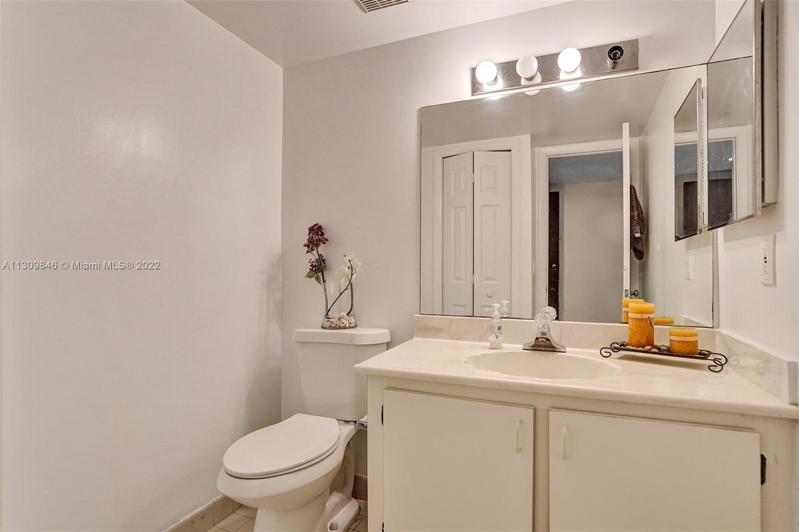 491 Racquet Club Road, Unit 101 Weston, FL 33326 - Photo 21 of 32 a bathroom with a sink toilet and mirror