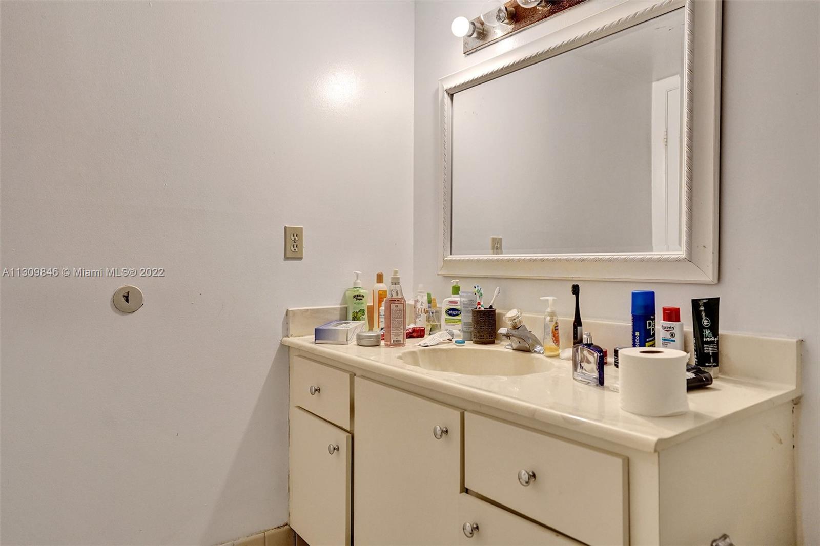 491 Racquet Club Road, Unit 101 Weston, FL 33326 - Photo 23 of 32 a bathroom with a sink and a mirror