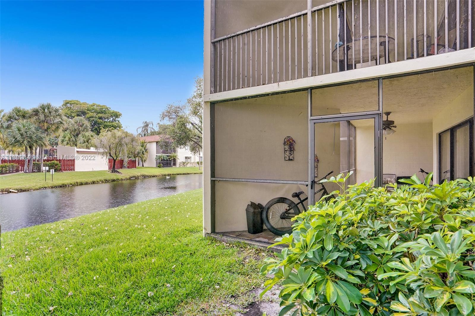 491 Racquet Club Road, Unit 101 Weston, FL 33326 - Photo 28 of 32 a backyard of a house with lots of green space and fountain