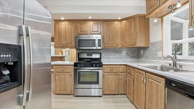 a kitchen with cabinets stainless steel appliances and a sink