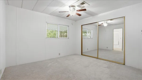 en empty room with windows and fan