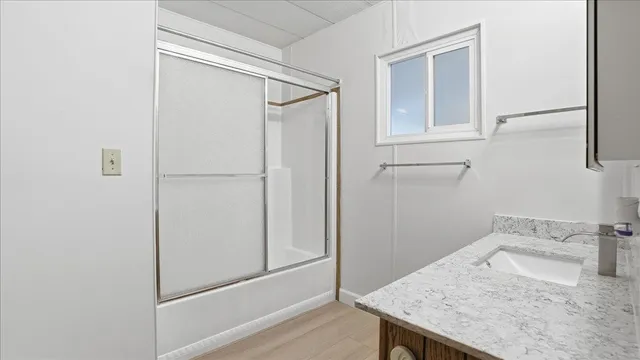 a bathroom with a granite countertop sink and shower