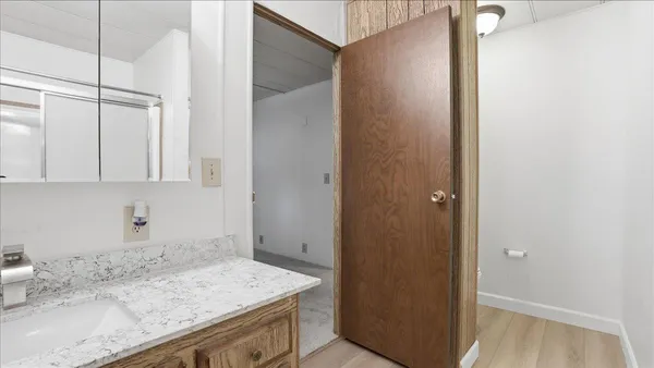 a bathroom with a granite countertop sink and white cabinets