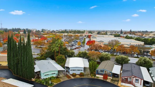 an aerial view of a house with a yard and large tree