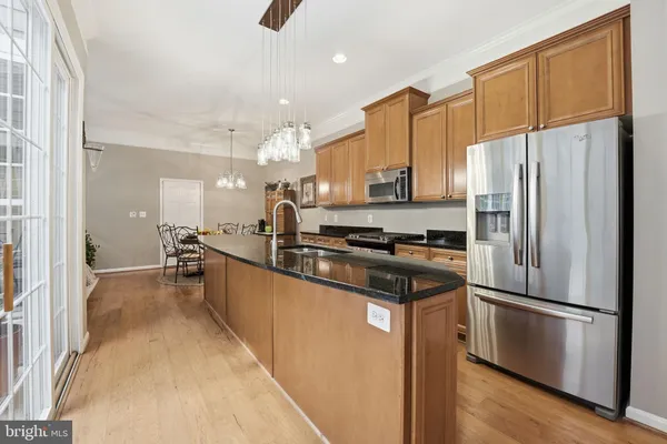 a kitchen with stainless steel appliances a refrigerator sink and white cabinets