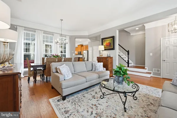 a living room with furniture potted plant and wooden floor
