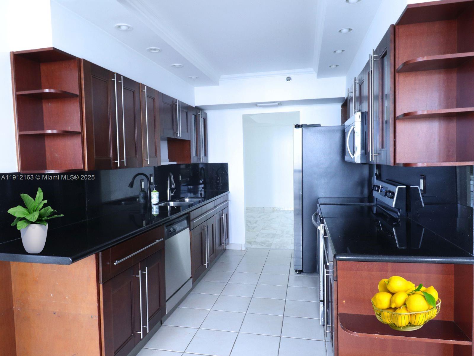 20191 East Country Club Drive, Unit 805 Aventura, FL 33180 - Photo 3 of 10 a kitchen with stainless steel appliances granite countertop a refrigerator and a stove