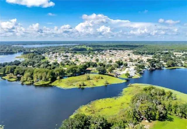 a view of a swimming pool with a table under an umbrella and wooden floor