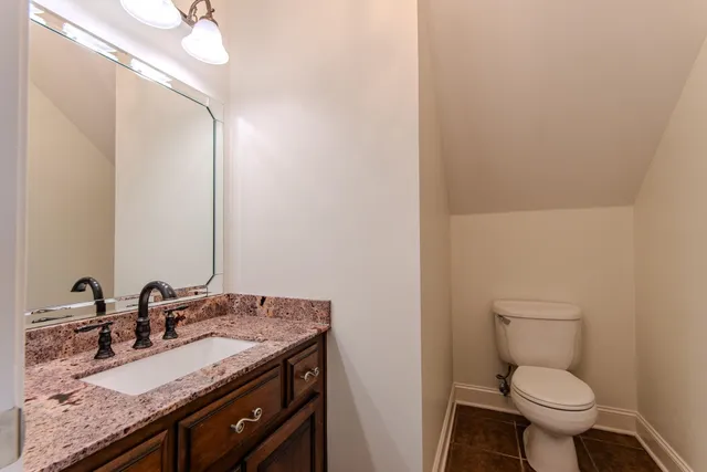 a bathroom with a granite countertop sink toilet and a mirror
