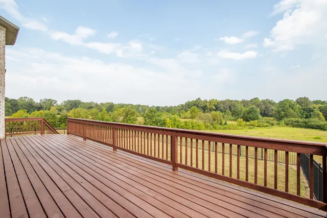 a view of balcony with wooden floor & fence