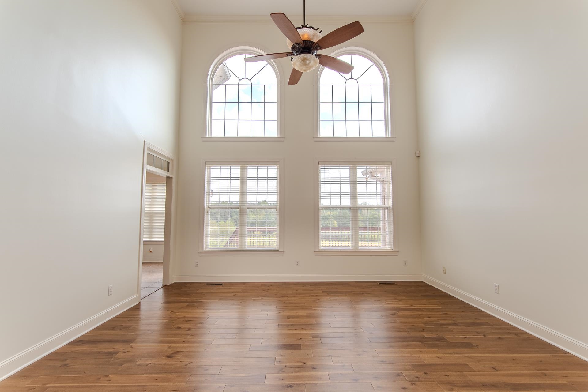 5166 Middlefork Road Luray, TN 38352 - Photo 7 of 40 an empty room with wooden floor fan and windows