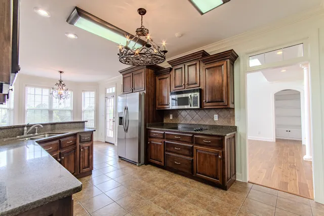 a kitchen with stainless steel appliances granite countertop a sink cabinets and stainless steel appliances