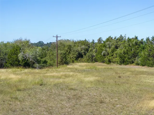 a view of a field with trees in the background