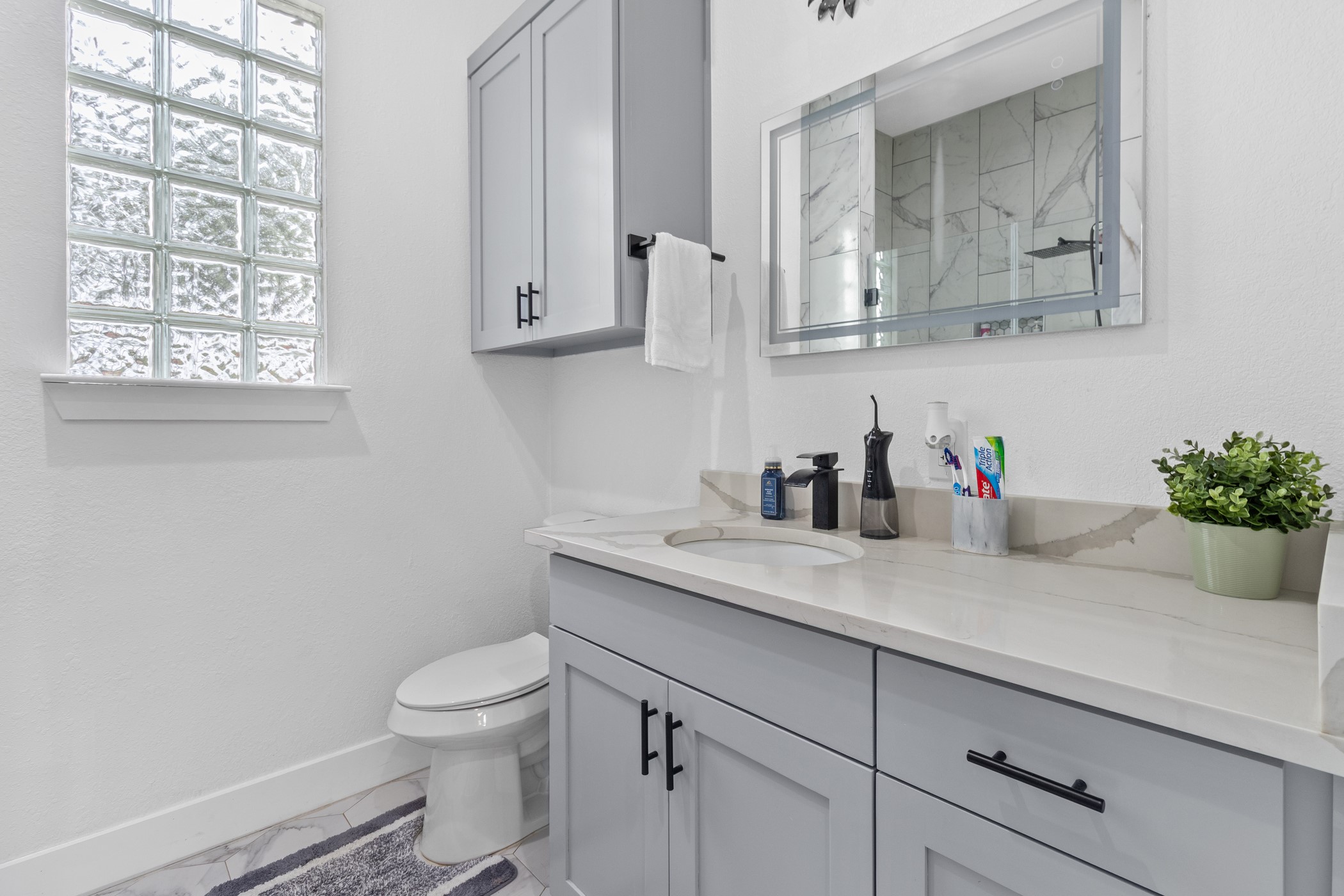 123 Zacate Street Elgin, TX 78621 - Photo 25 of 33 Bathroom featuring a light gray vanity with a built-in sink, light-toned countertop, and black hardware