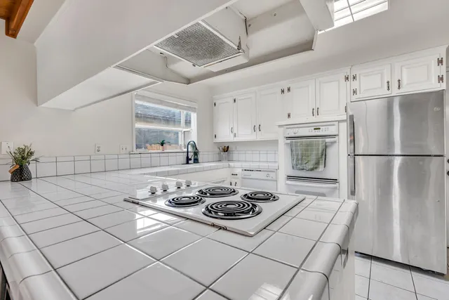 a kitchen with a stove a refrigerator and a cabinets