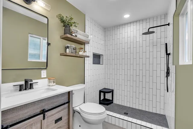 a bathroom with a sink a toilet and shower