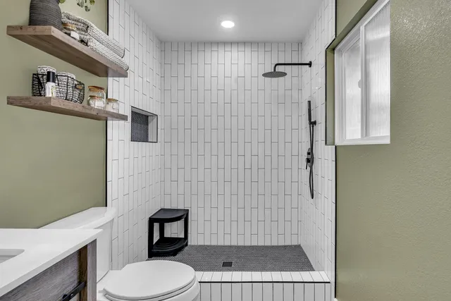 a bathroom with a toilet and a shower