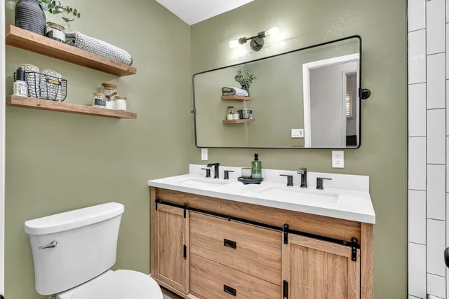 a bathroom with a toilet sink and mirror