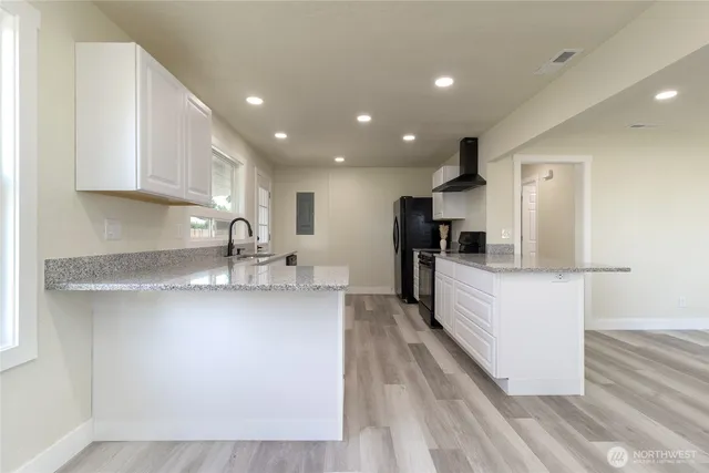 a large kitchen with stainless steel appliances a large counter top a stove and a refrigerator