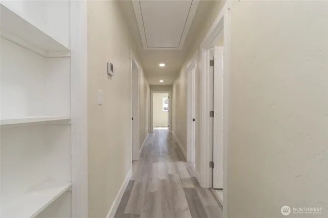 a view of a hallway with wooden floor