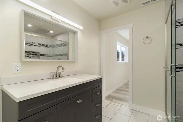 a bathroom with a sink vanity and a mirror