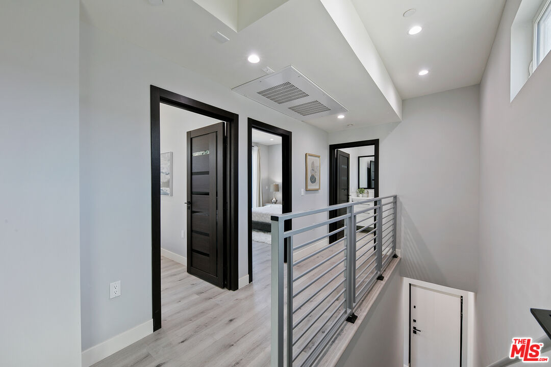 15106 Roxford Street, Unit 13621 Los Angeles, CA 91342 - Photo 12 of 22 a hallway with a large mirror and dresser