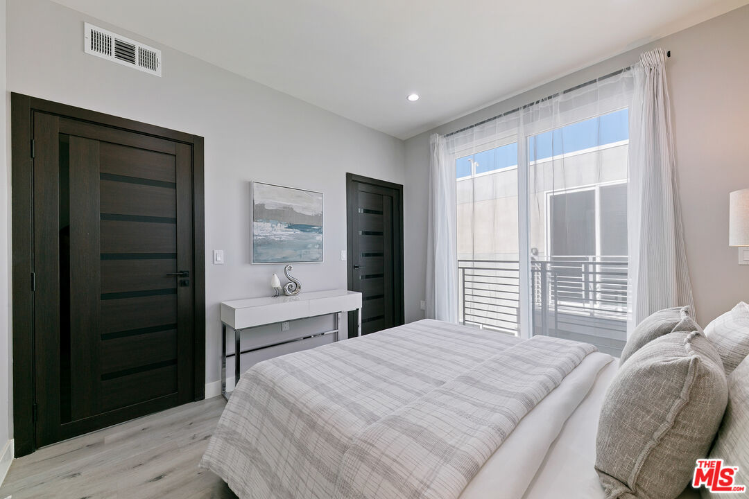 15106 Roxford Street, Unit 13621 Los Angeles, CA 91342 - Photo 14 of 22 a bedroom with a bed and a window