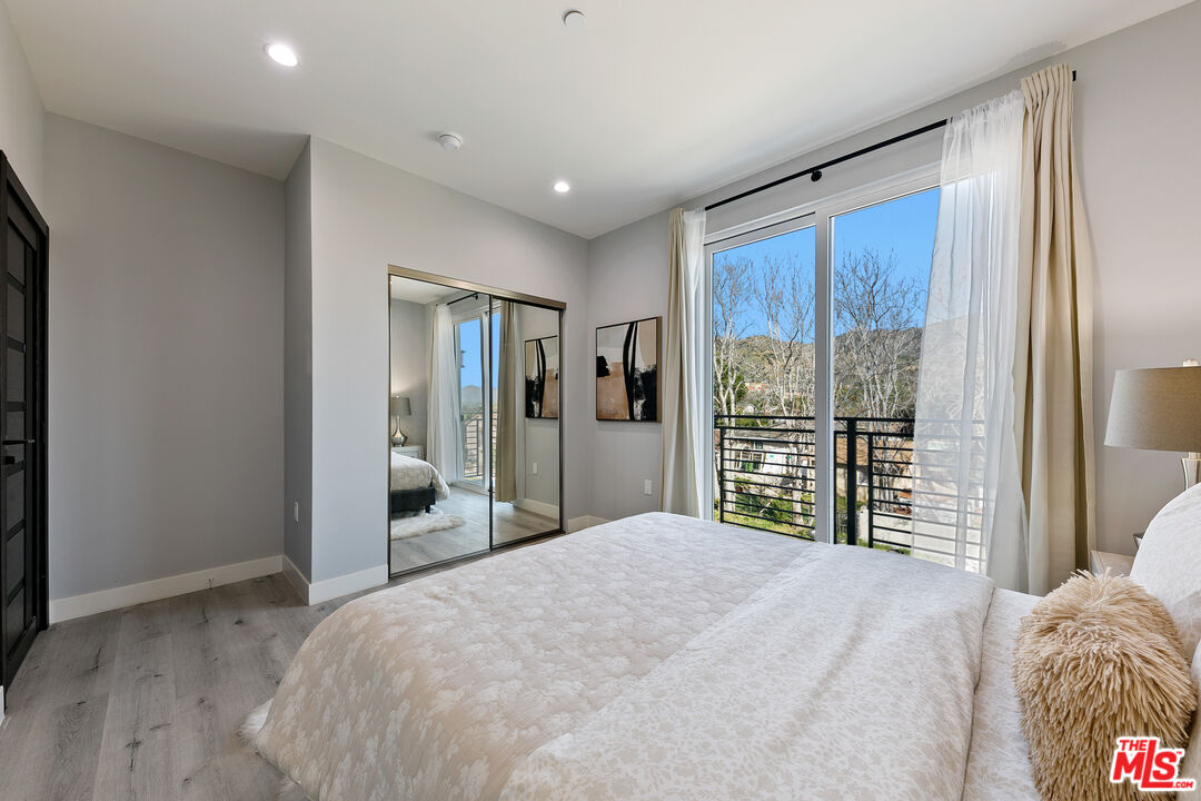 15106 Roxford Street, Unit 13621 Los Angeles, CA 91342 - Photo 15 of 22 a bedroom with a large bed and a large window