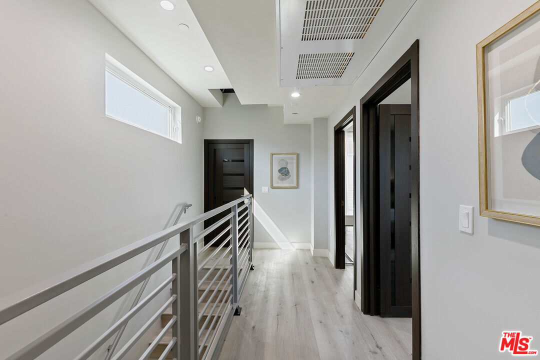 15106 Roxford Street, Unit 13621 Los Angeles, CA 91342 - Photo 17 of 22 a hallway with wooden floor and staircase