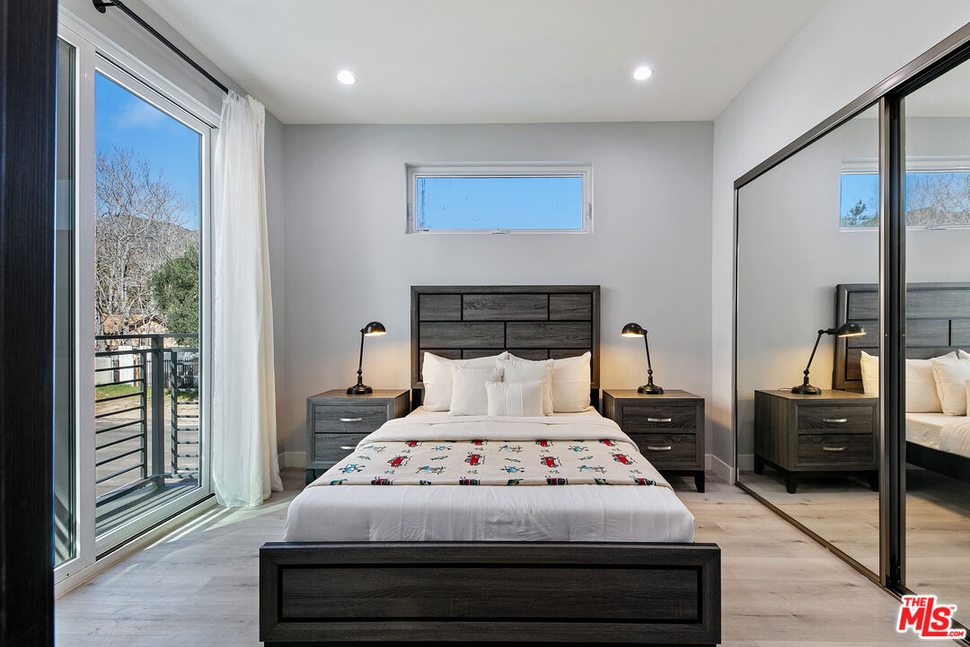 15106 Roxford Street, Unit 13621 Los Angeles, CA 91342 - Photo 20 of 22 a bedroom with a bed and wooden floor