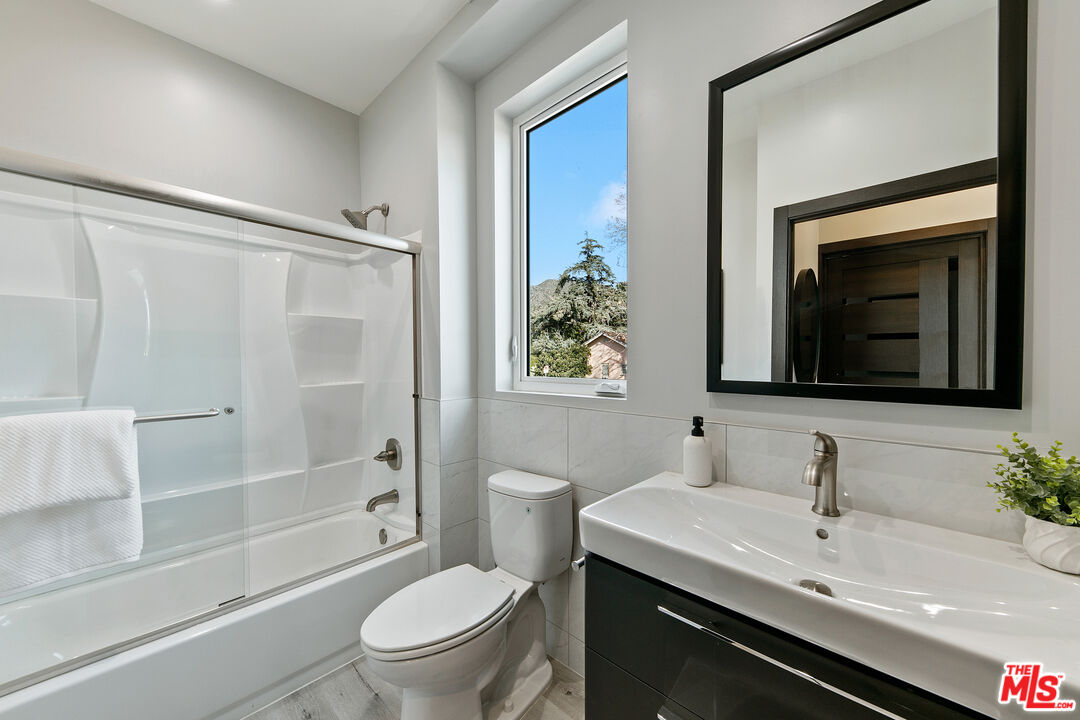 15106 Roxford Street, Unit 13621 Los Angeles, CA 91342 - Photo 9 of 22 a bathroom with a granite countertop sink toilet and shower
