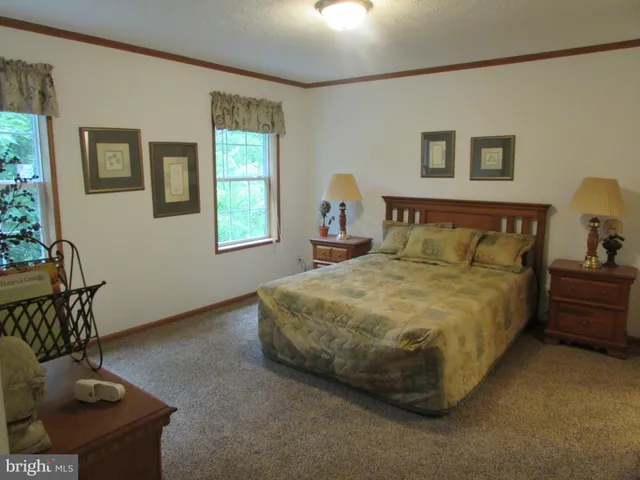 a bedroom with a bed couches and window