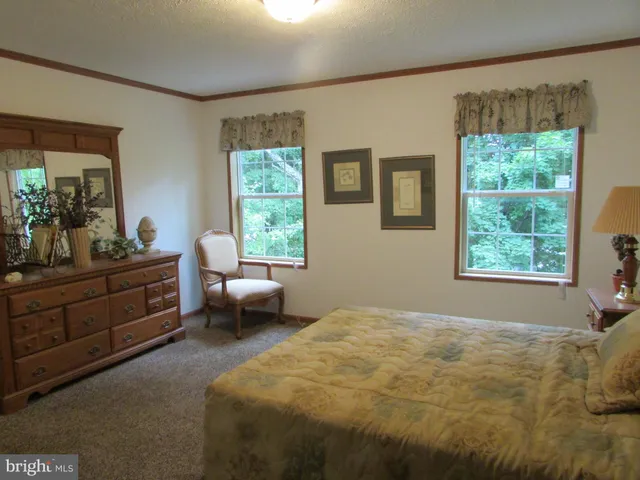 a bedroom with a bed and painting on the wall