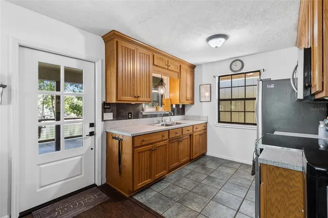 a kitchen with stainless steel appliances granite countertop a stove a sink and a refrigerator
