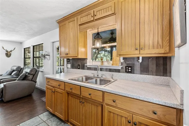 a kitchen with granite countertop a sink and a white wooden cabinets