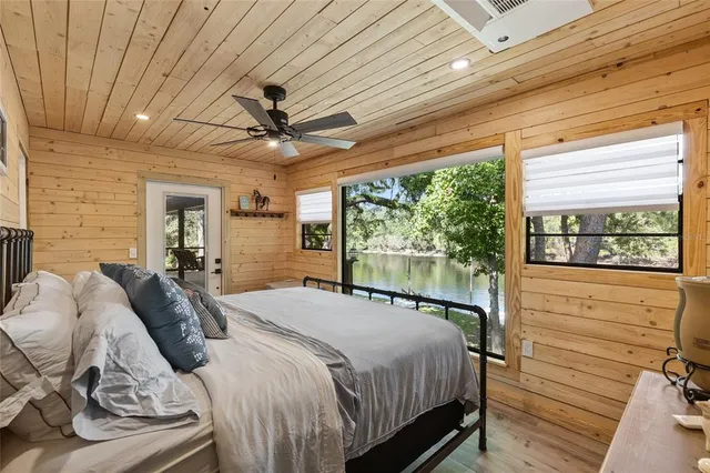 a bedroom with a bed and large windows