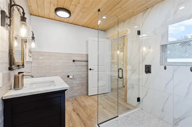 a bathroom with a shower sink and mirror