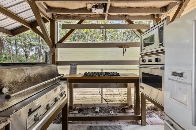 a front view of a house with a yard outdoor seating and covered with trees