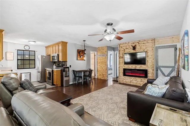 a living room with furniture and a flat screen tv with kitchen view